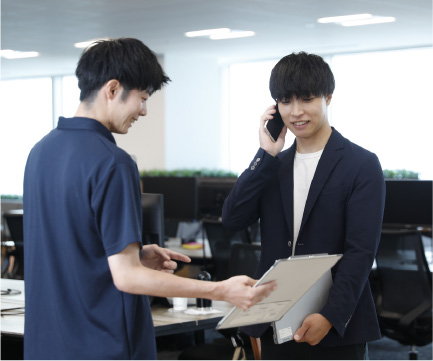 二人の社員が向き合って話している様子