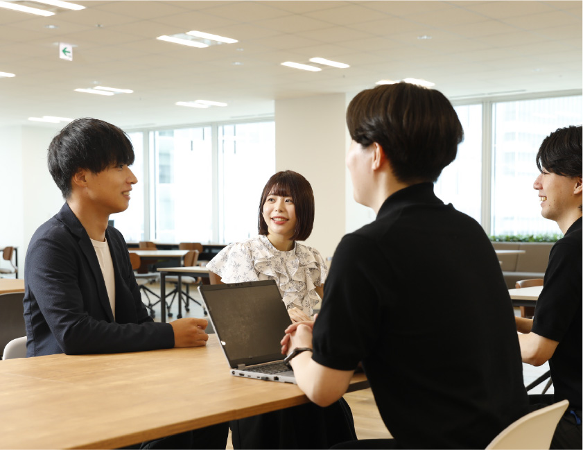 会議室で複数の社員がテーブルを囲んで談笑している様子